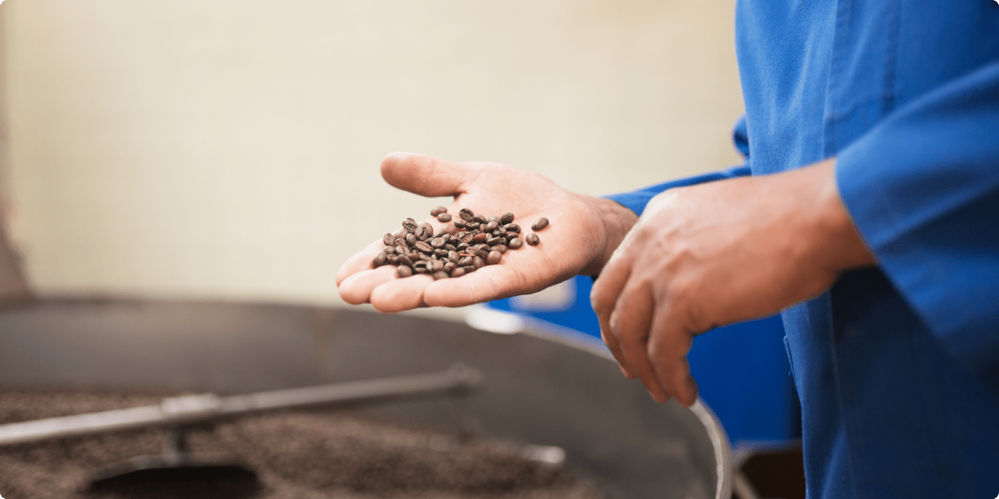 close-up-man-holding-roasted-coffee-beans